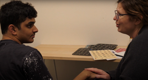 Listen to Us: Still of a teenage boy with autism sitting with his speech therapist